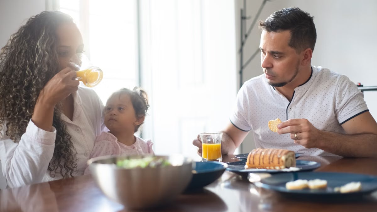 A family having breakfast at home, sharing food and drinks, embodying togetherness and love.